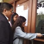 Tres personas están en una ventanilla.