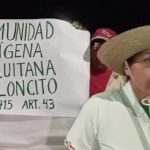 Persona con sombrero hablando frente a una pancarta que dice 'Comunidad Indígena Chiquitana Pailoncito Ley 1715 Art. 43'.