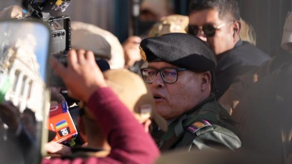 Un hombre con uniforme militar rodeado de personas y cámaras.