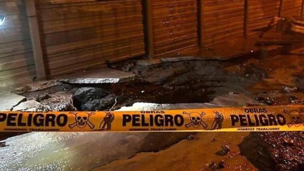 Imagen de una calle con un socavón y cinta amarilla de advertencia.
