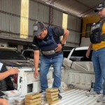 Personas en un almacén revisando mercancía en la parte trasera de un vehículo.
