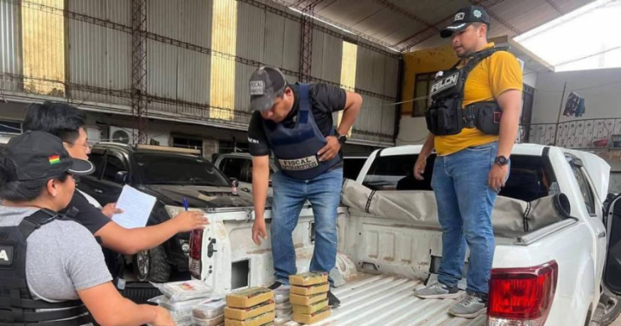 Personas en un almacén revisando mercancía en la parte trasera de un vehículo.