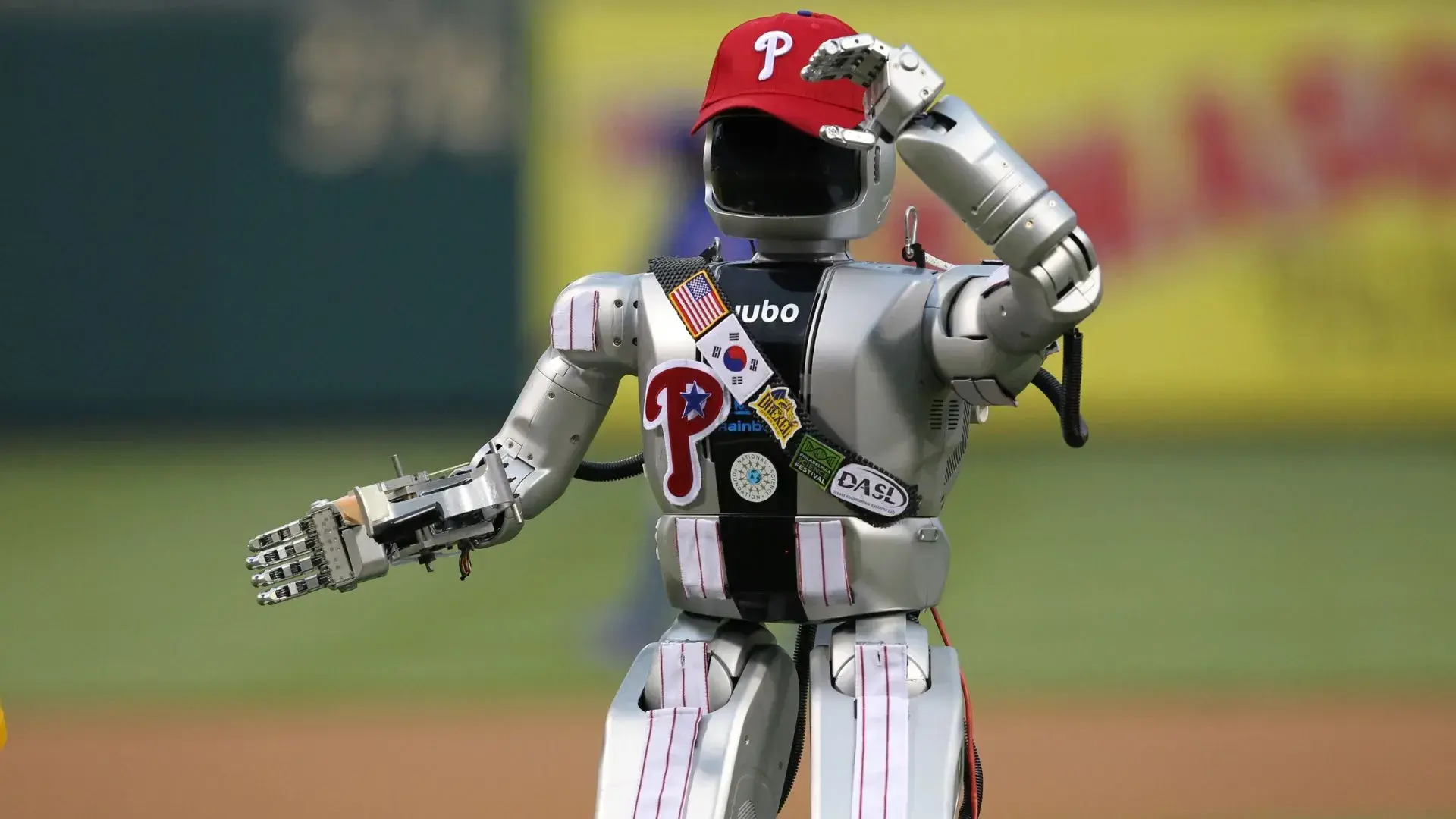 Un robot humanoide lanzando la primera pelota en un partido de béisbol. / Hunter Martin/Getty Images / Información de la fuente de la imagen no disponible