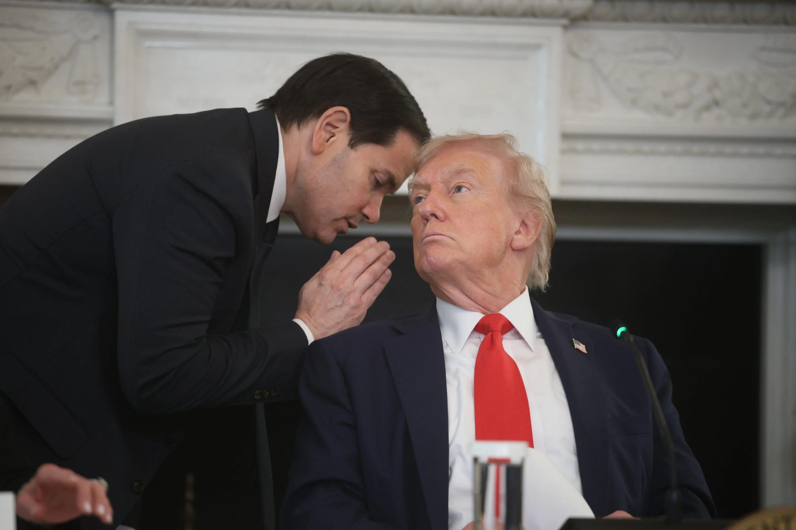 Secretario de Estado Marco Rubio susurra al presidente Donald Trump durante una mesa redonda en la Casa Blanca.