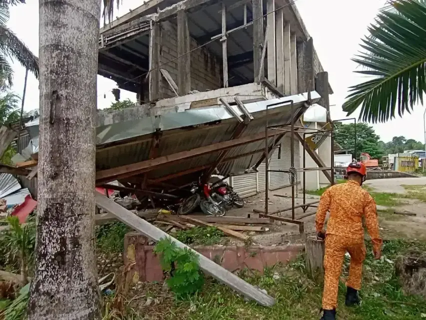 Bombero se acerca a una estructura derrumbada por el terremoto en Filipinas.