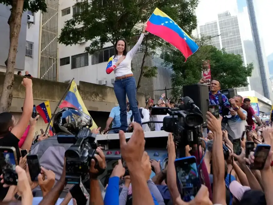 María Corina Machado sostiene la bandera venezolana frente a la Fiscalía en Caracas en 2014.
