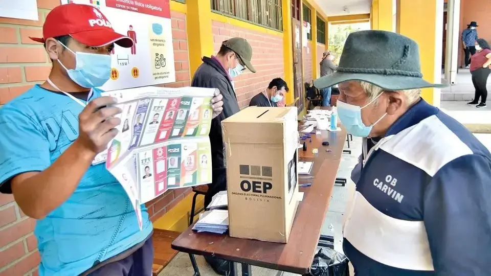 Un votante observa la papeleta electoral en un recinto, en las elecciones generales de 2020.