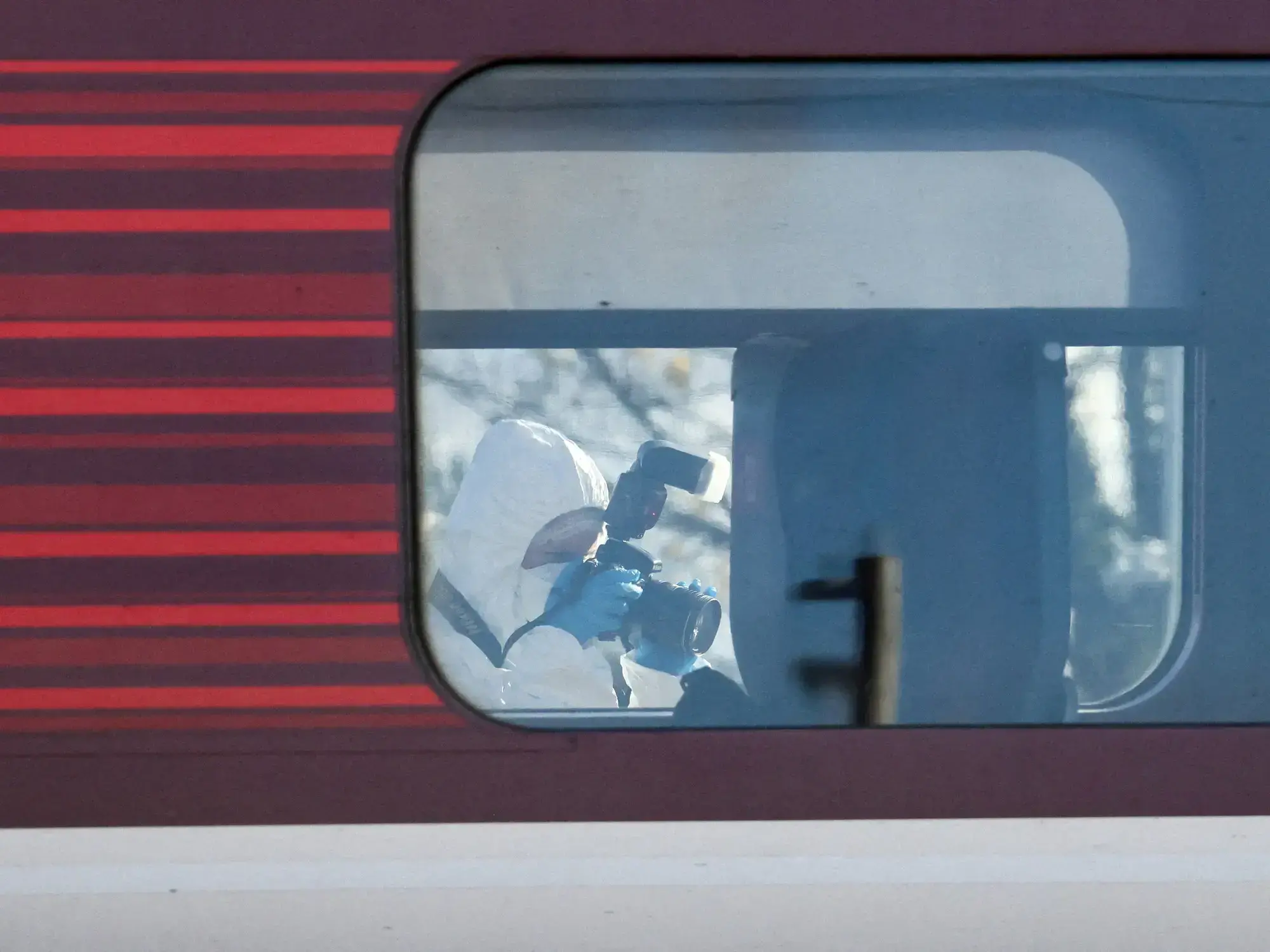 Un forense toma fotos dentro del tren donde sucedió el ataque.
