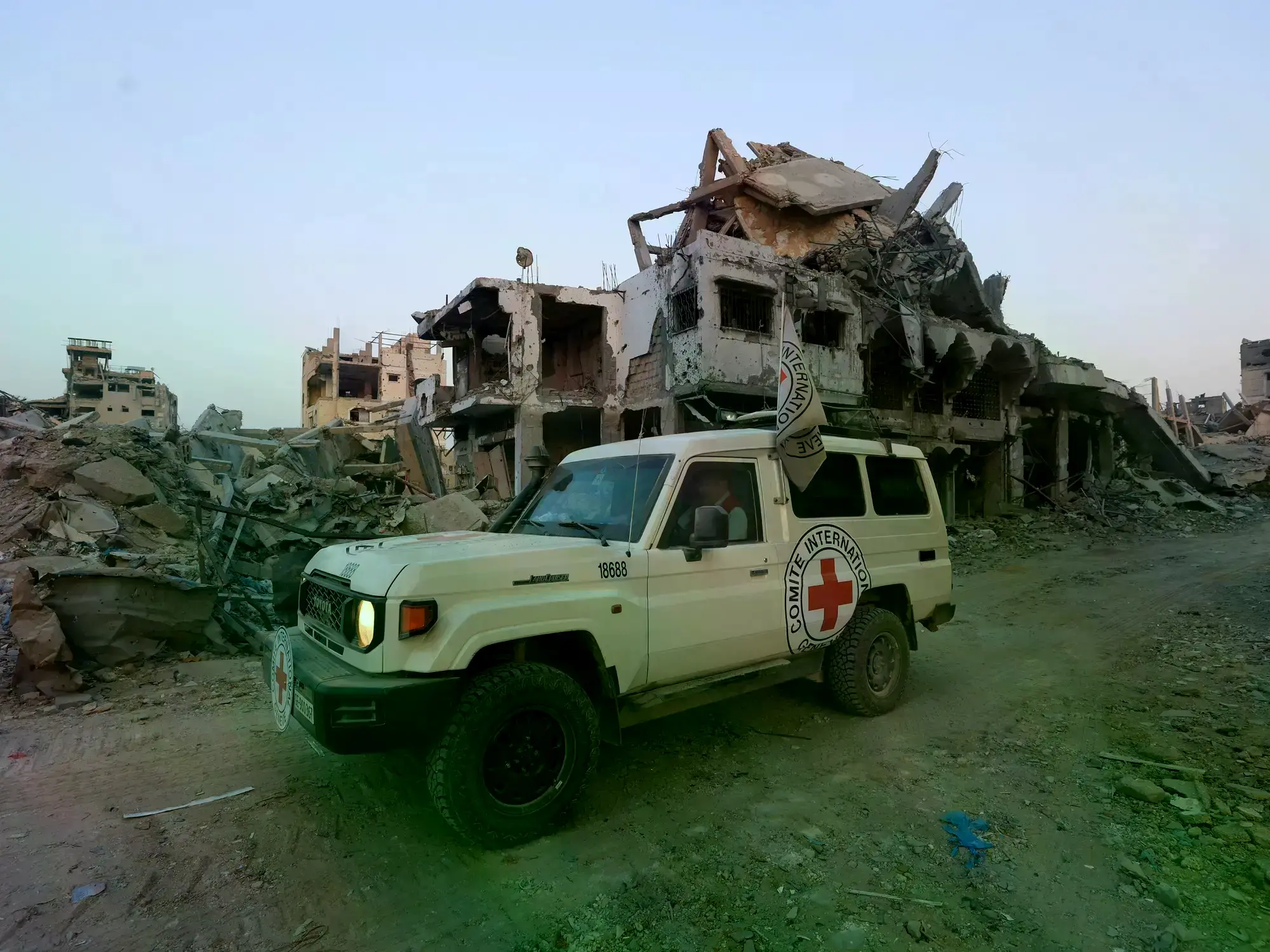 Un vehículo de la Cruz Roja junto a edificios dañados en Gaza.