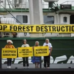Activistas de Oxfam portan marionetas de líderes mundiales durante una protesta previa a la COP30 en Belém.