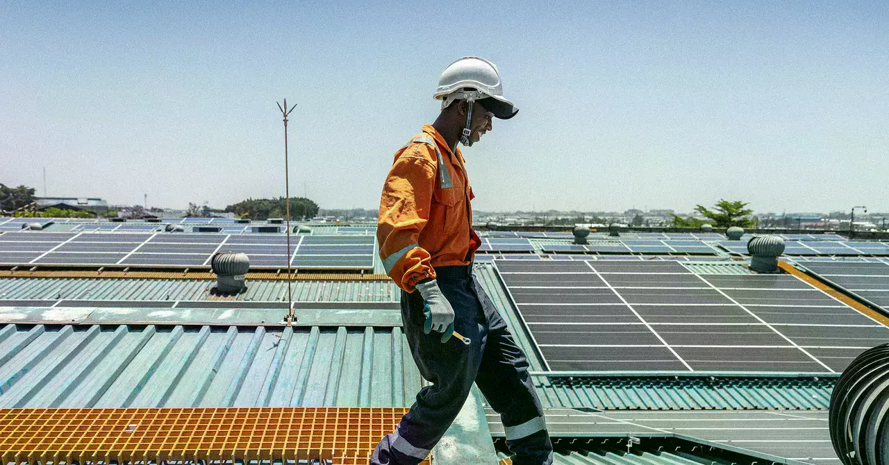 Un técnico trabajando en el mantenimiento de paneles solares en Nairobi, Kenia.