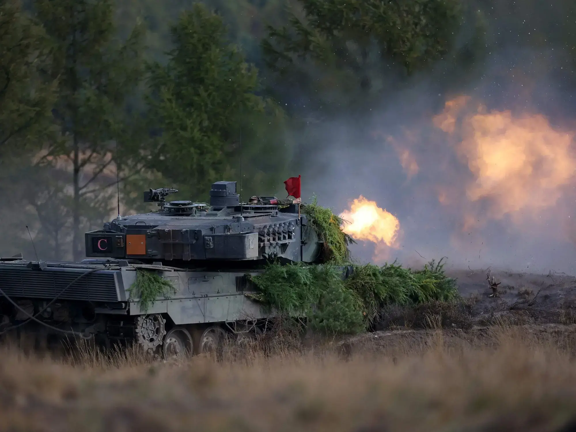 Un tanque Leopard 2 de las Fuerzas Armadas alemanas dispara durante una visita de la canciller en el campo militar de Ostenho