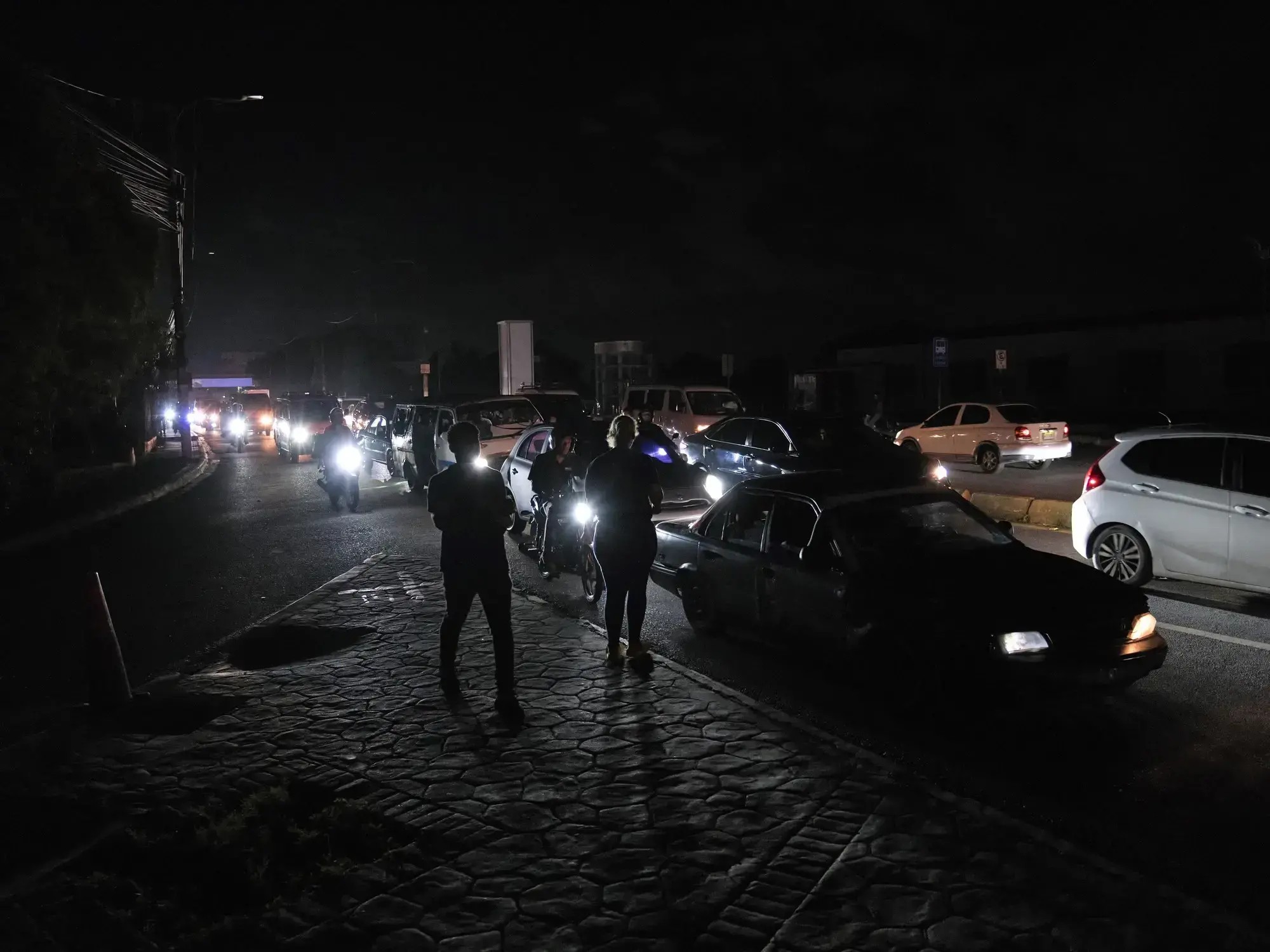 Vehículos avanzan por una calle a oscuras en Santo Domingo