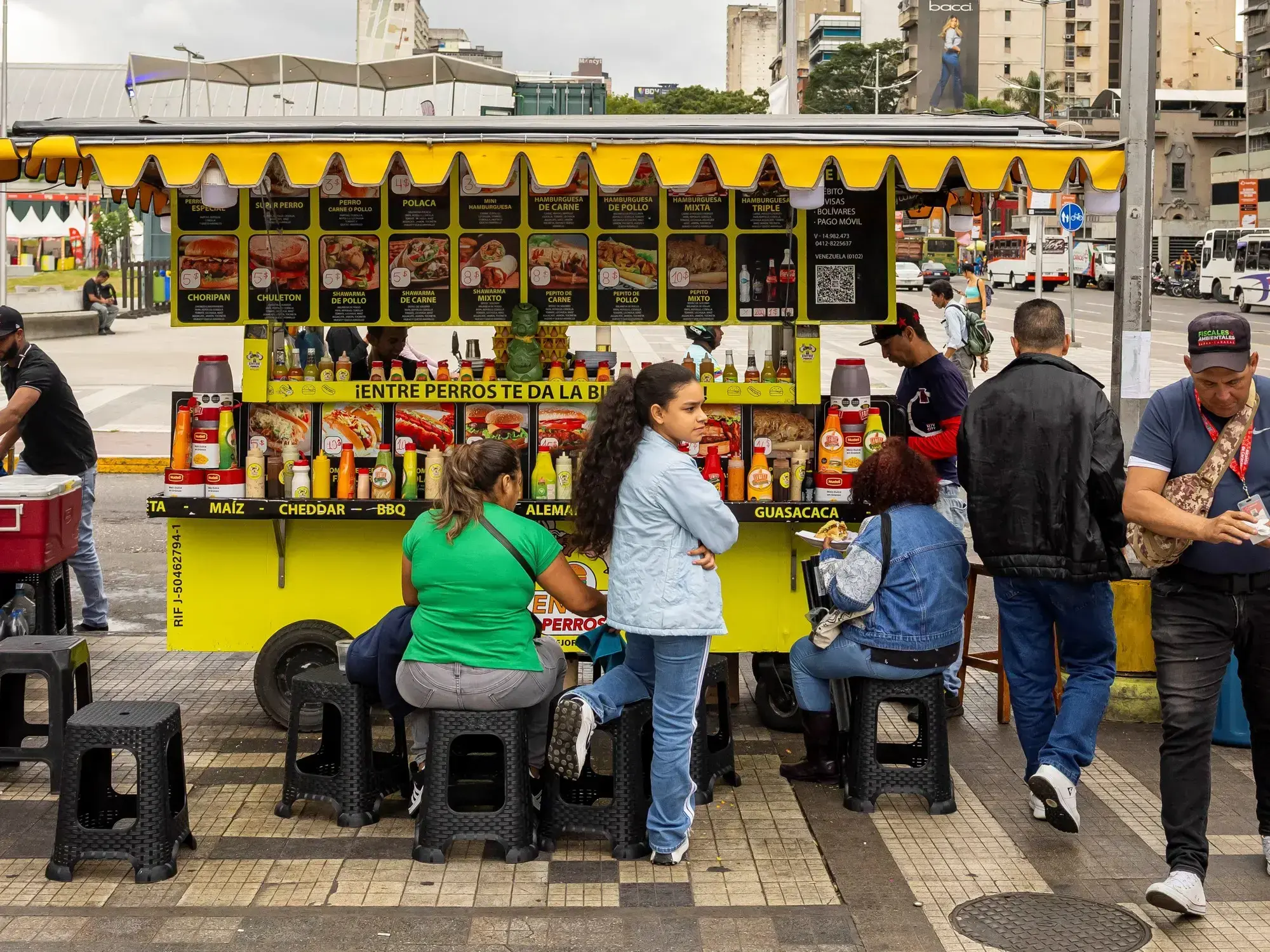 Personas compran alimentos en un puesto informal en Caracas