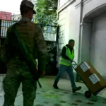 Un empleado del servicio electoral de Chile lleva material para la elección de este domingo, en un centro de votación en Sant