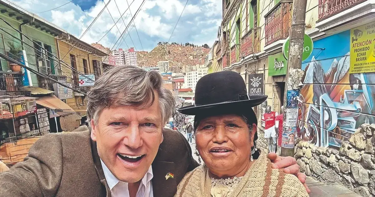 Christopher Landau posa junto a una mujer paceña de sombrero borsalino, manta y pollera