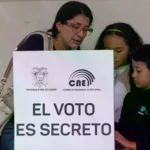 Una votante deposita su voto junto a sus hijos en un referéndum en Quito, Ecuador