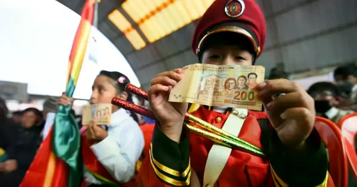 Niños recibiendo su bono de Bs 200