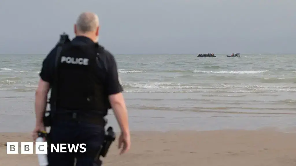 Policías franceses observan una embarcación en una playa del norte de Francia