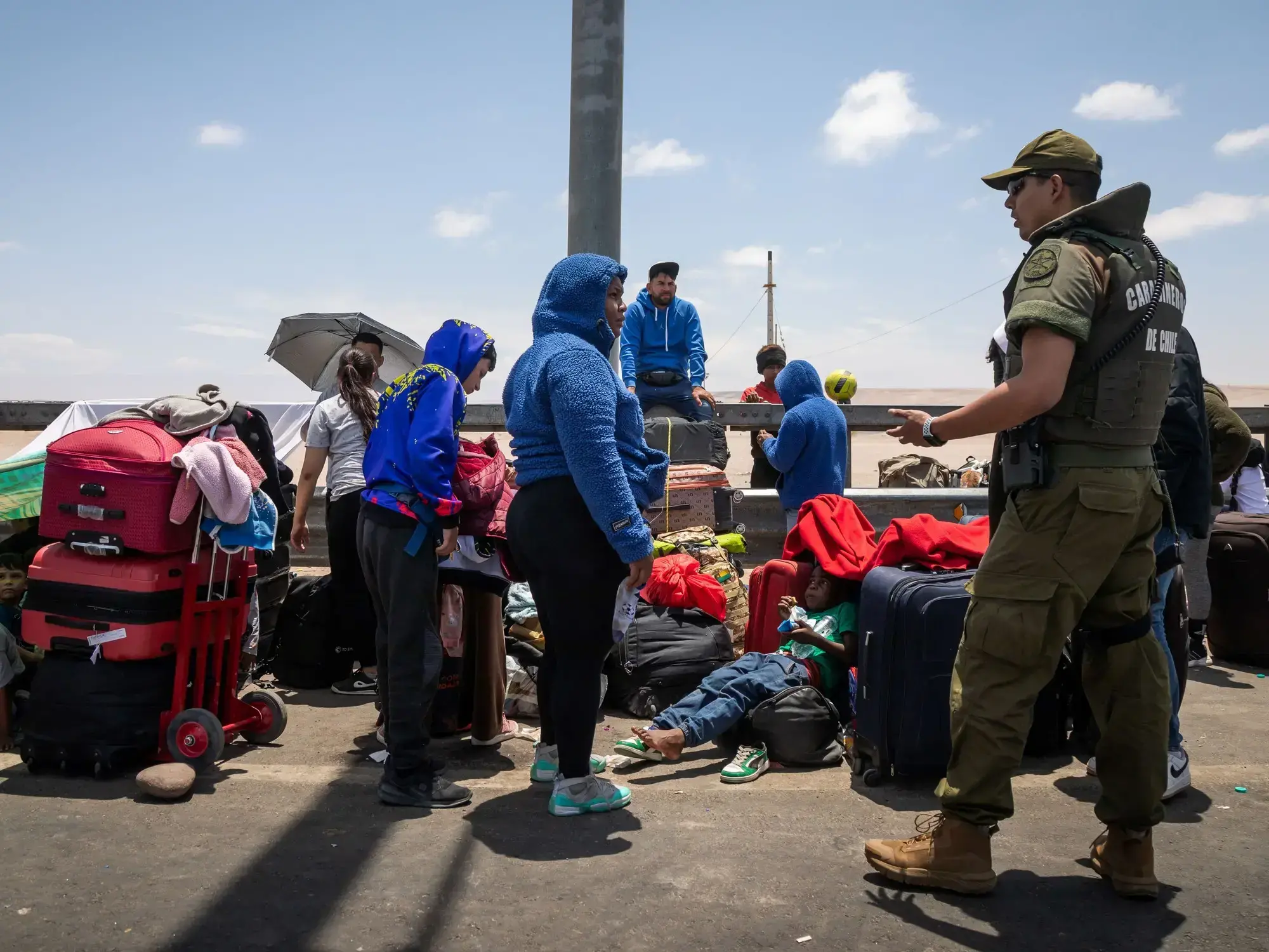Migrantes, en su mayoría venezolanos, esperando cruzar a Perú en el paso fronterizo de Chacalluta, en Arica, Chile.