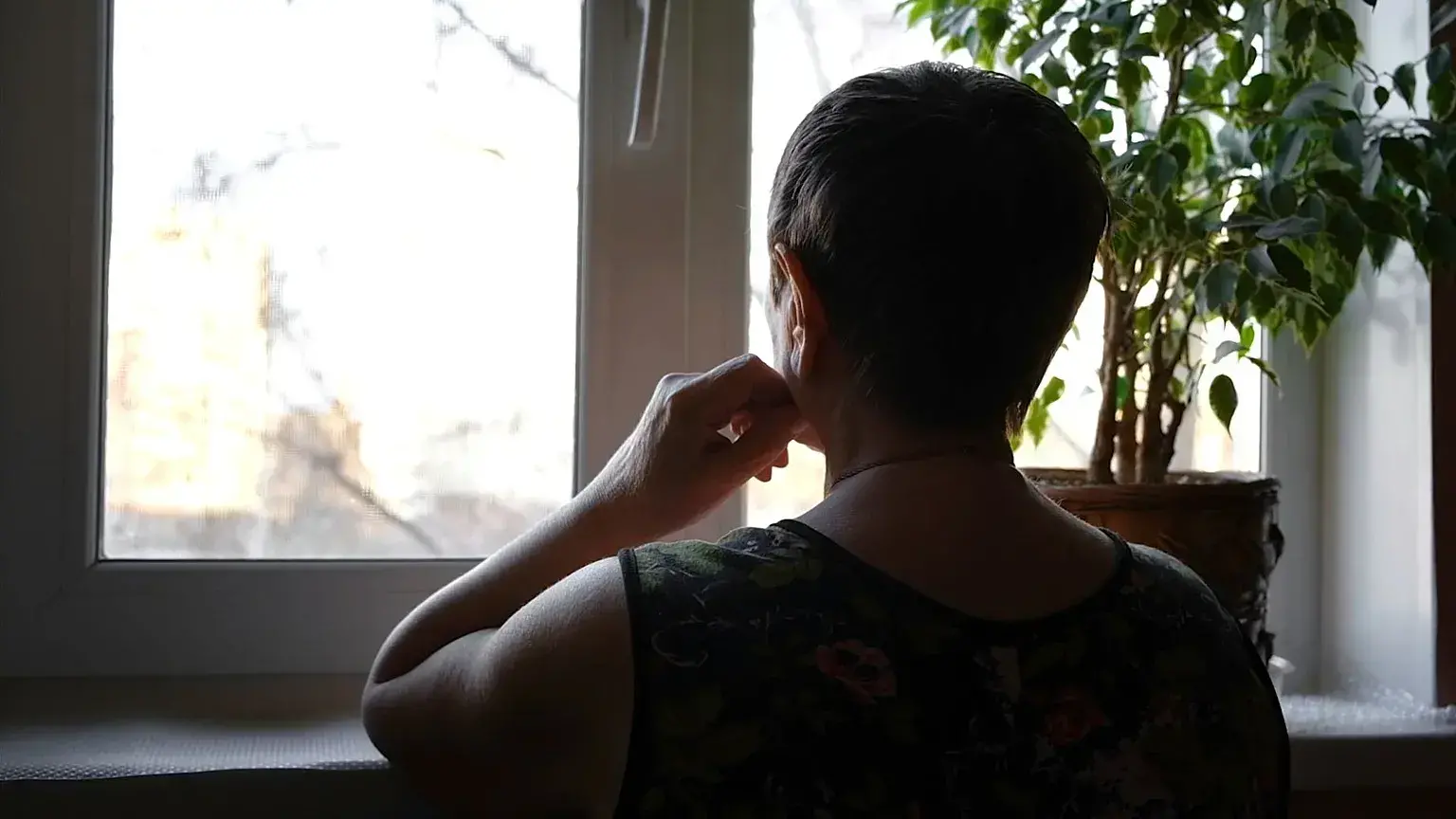 Una mujer mira por la ventana