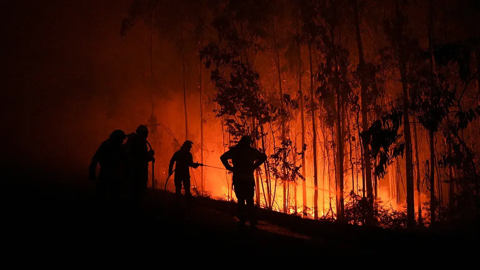 Bomberos trabajan mientras avanza un incendio en Ponteceso, noroeste de España.