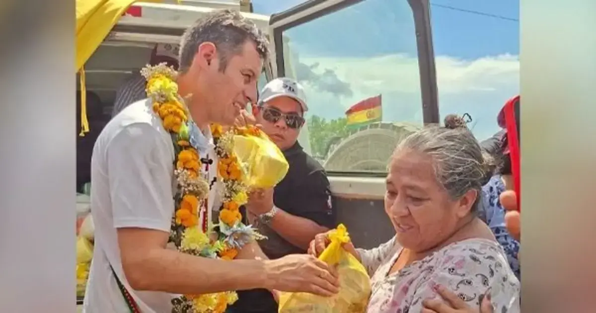 Edmand Lara entrega ayuda a una mujer