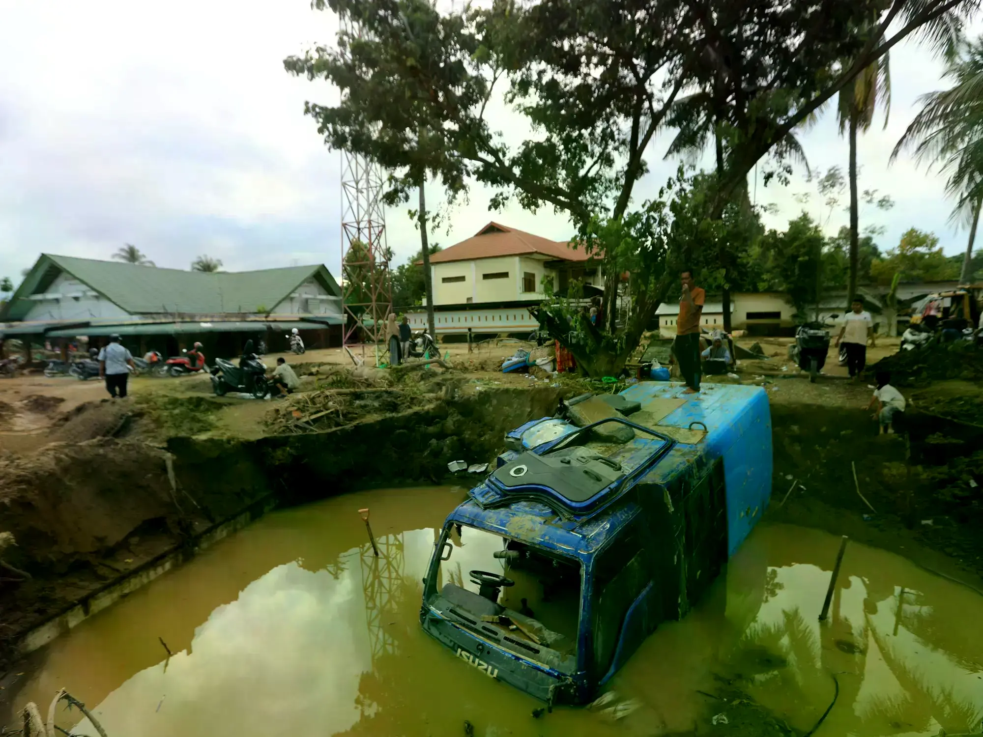 Un camión sepultado en el lodo en una aldea afectada por las inundaciones en Aceh, Indonesia.