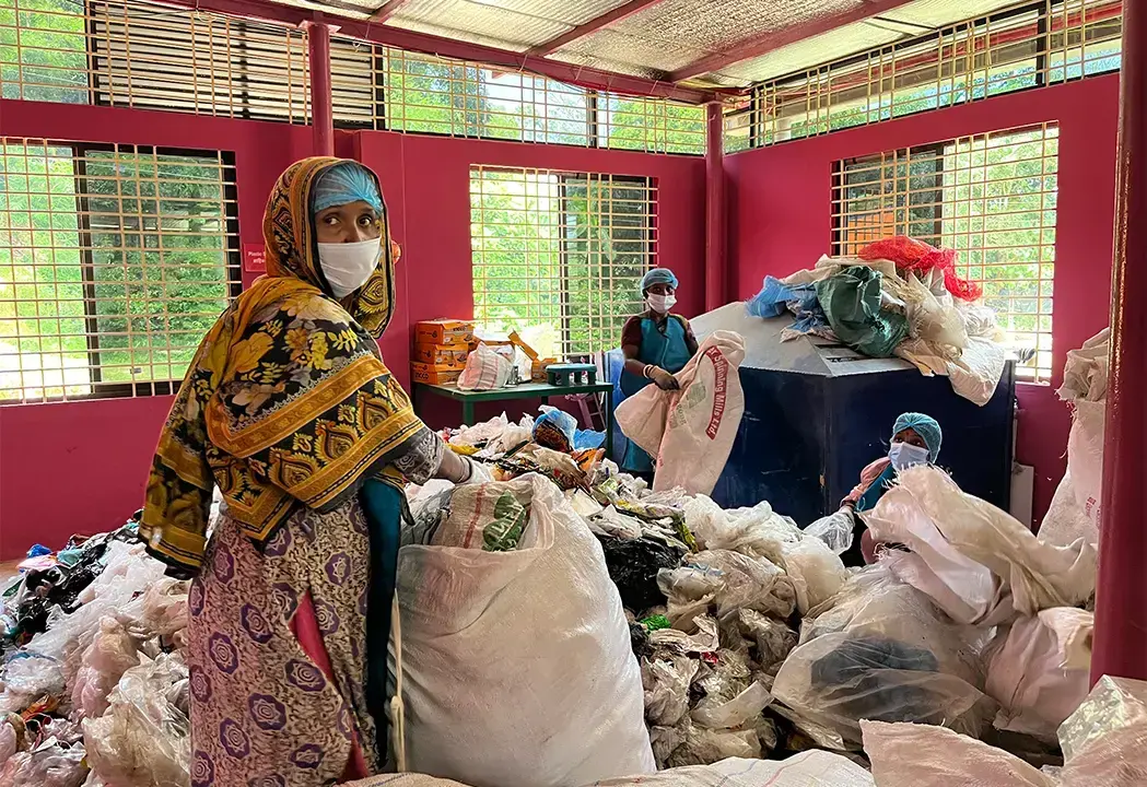 Trabajadores en el proyecto de plástico de BRAC clasifican residuos.