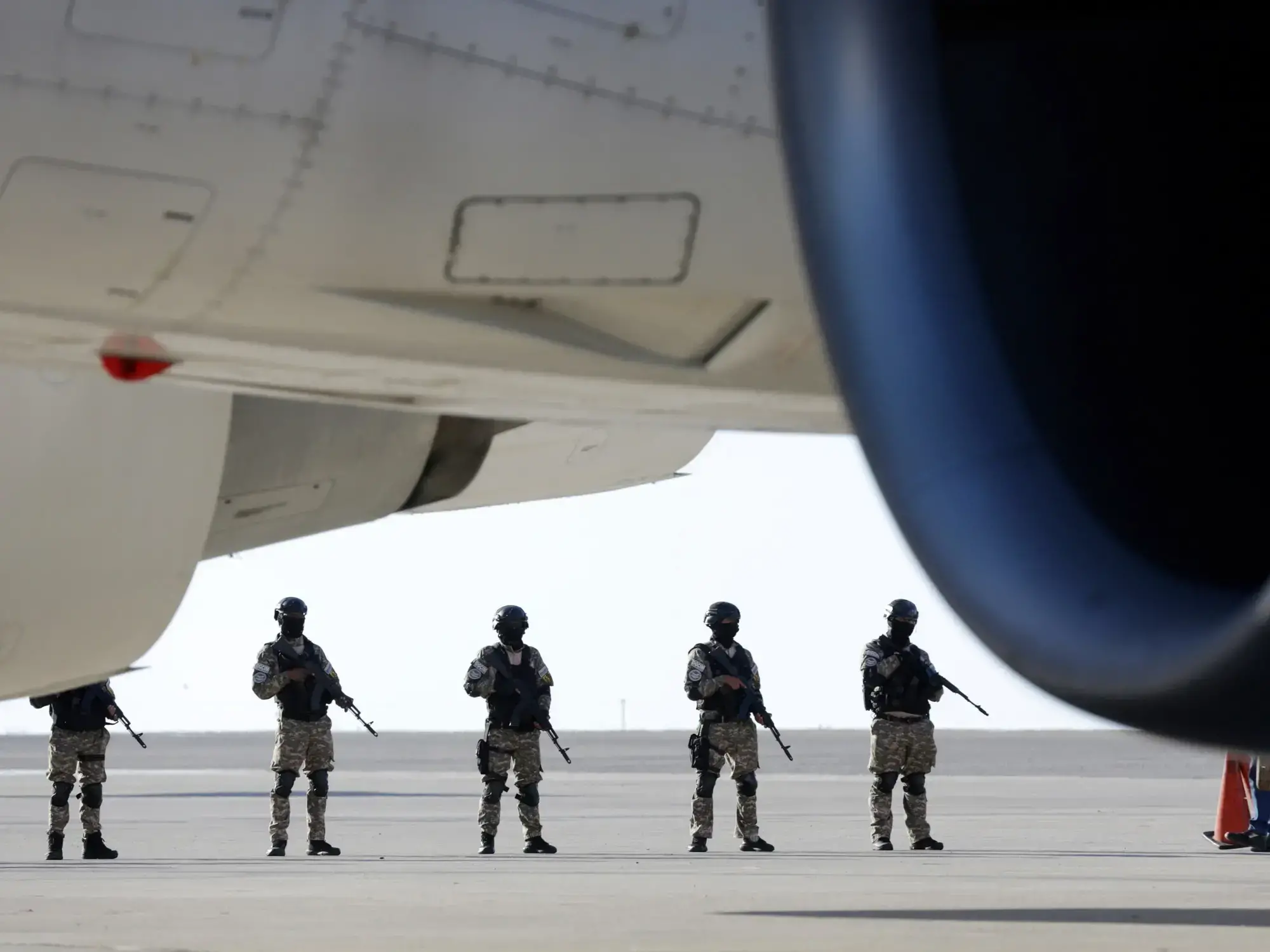 La policía monta guardia mientras un vuelo estadounidense con migrantes deportados aterriza en el Aeropuerto Simón Bolívar de