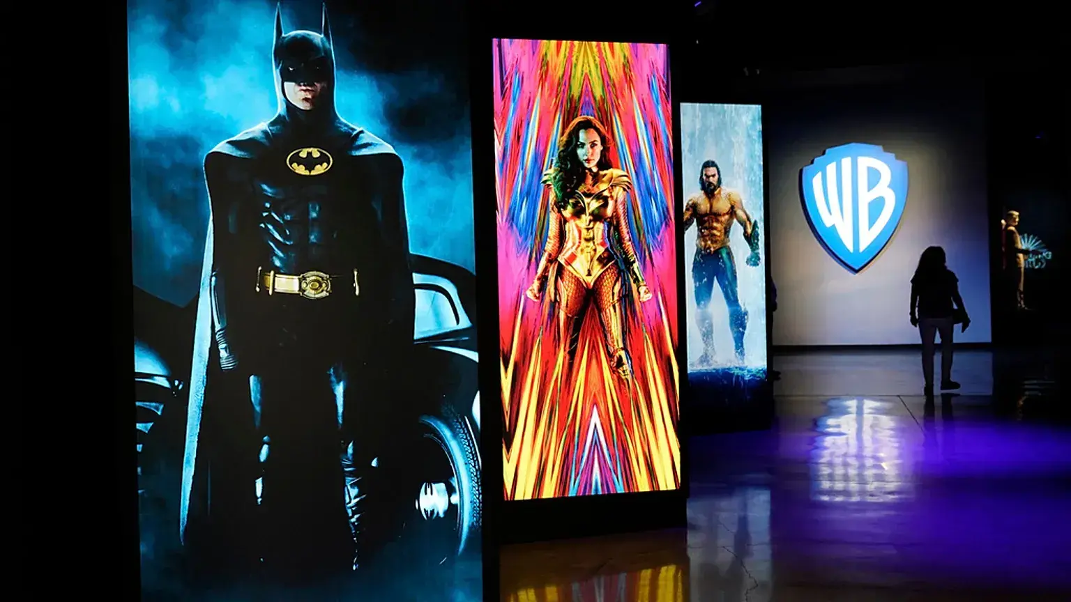 Una visitante pasa junto a retratos de superhéroes de DC Comics en el Warner Bros. Studio Tour Hollywood.