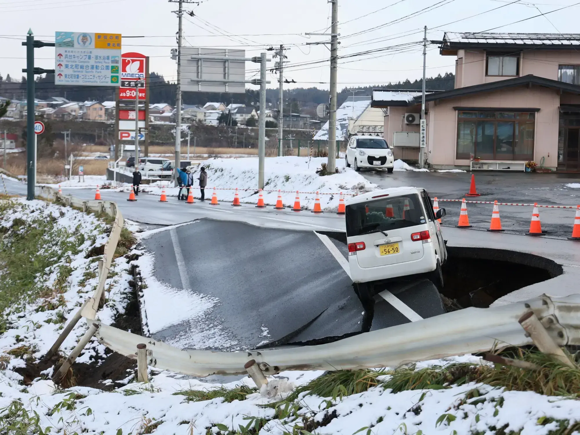 Un auto atrapado en un enorme cráter provocado por el terremoto en Japón.