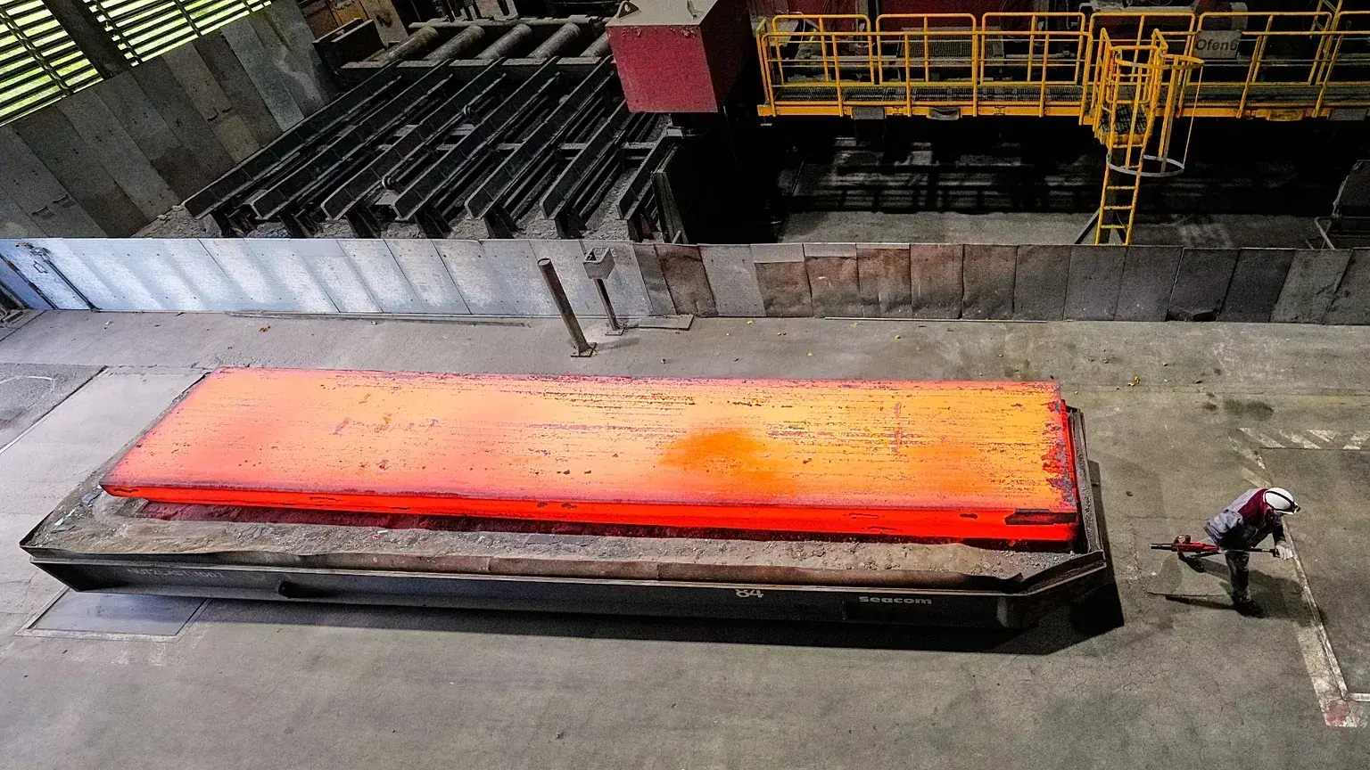 Un hombre pasa junto a una plancha de acero al rojo vivo en la acería de Thyssenkrupp en Duisburgo, Alemania.