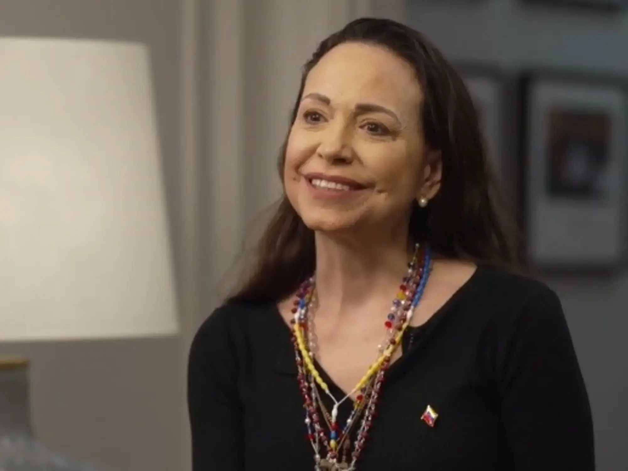 María Corina Machado saluda desde el balcón de su hotel en Oslo.