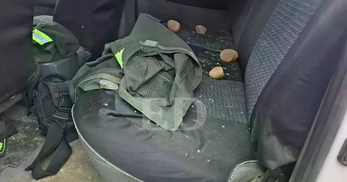 Patrulla policial dañada tras el ataque con piedras.