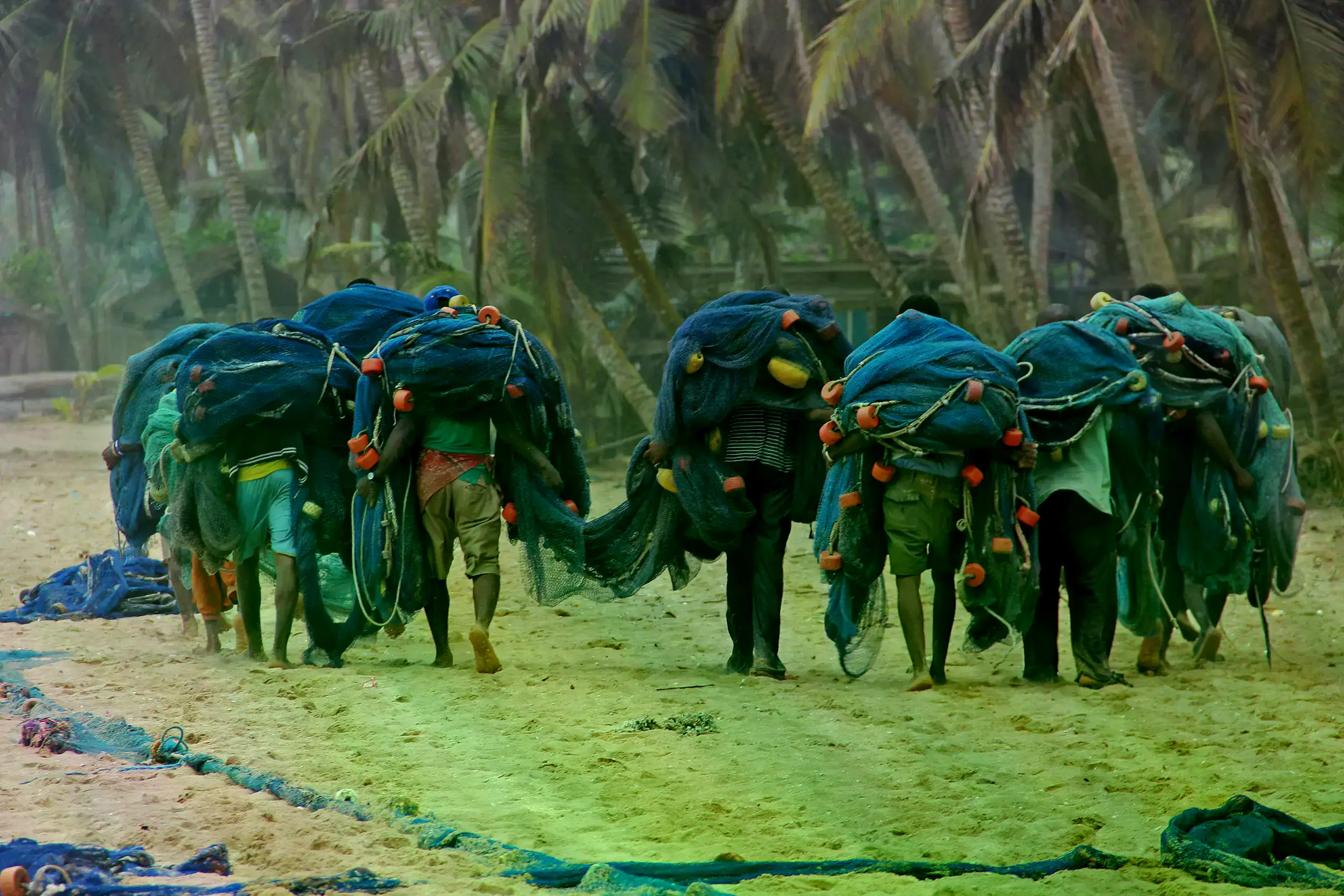 Pescadores en Ghana cargan sus redes en la playa.