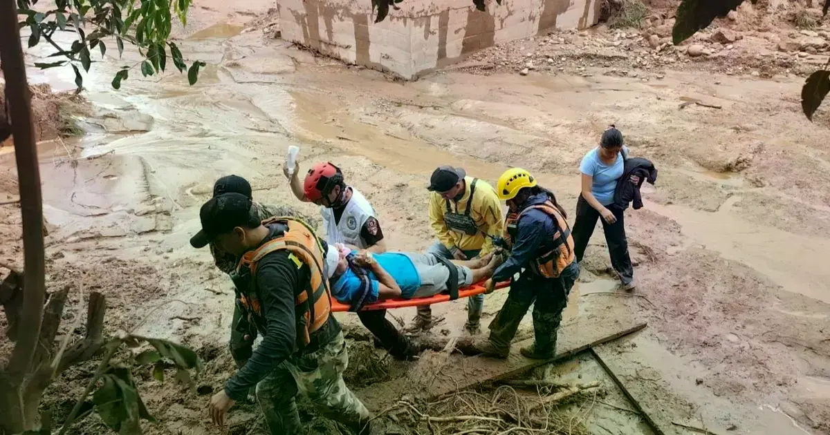 Rescatistas auxilian a una persona afectada por la riada de El Torno.