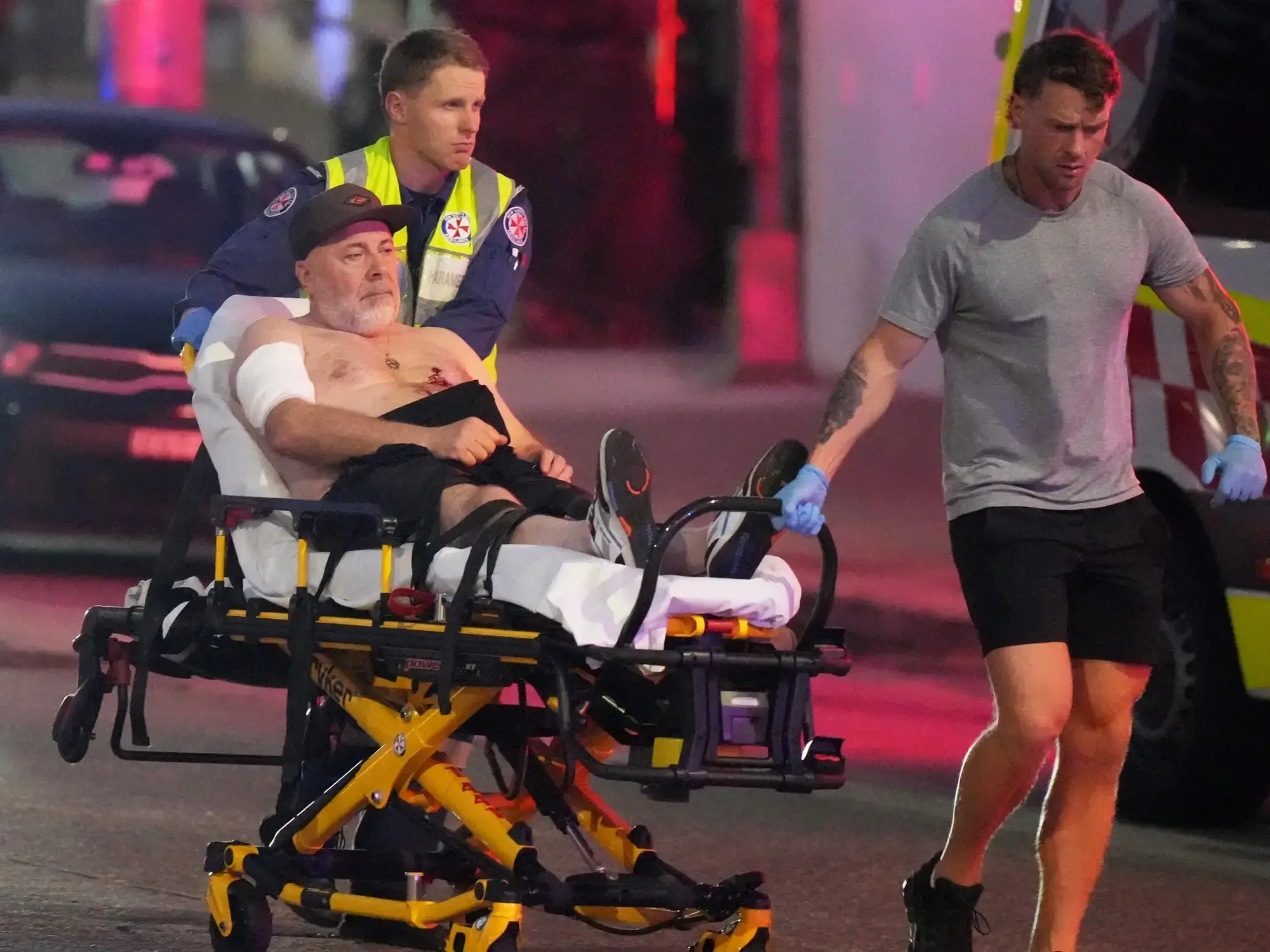 Los equipos de emergencia transportan a una persona en camilla tras un tiroteo en Bondi Beach, Sídney.