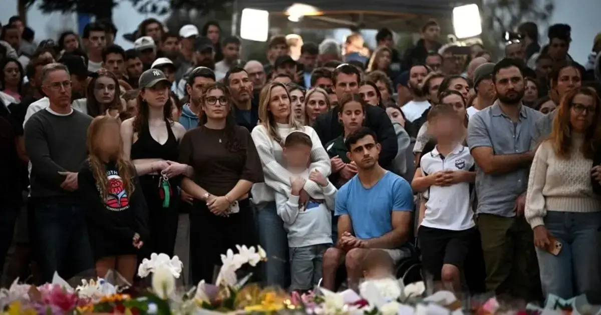 Dolientes asisten a una vigilia en un monumento conmemorativo en Bondi Beach en Sídney, Australia.