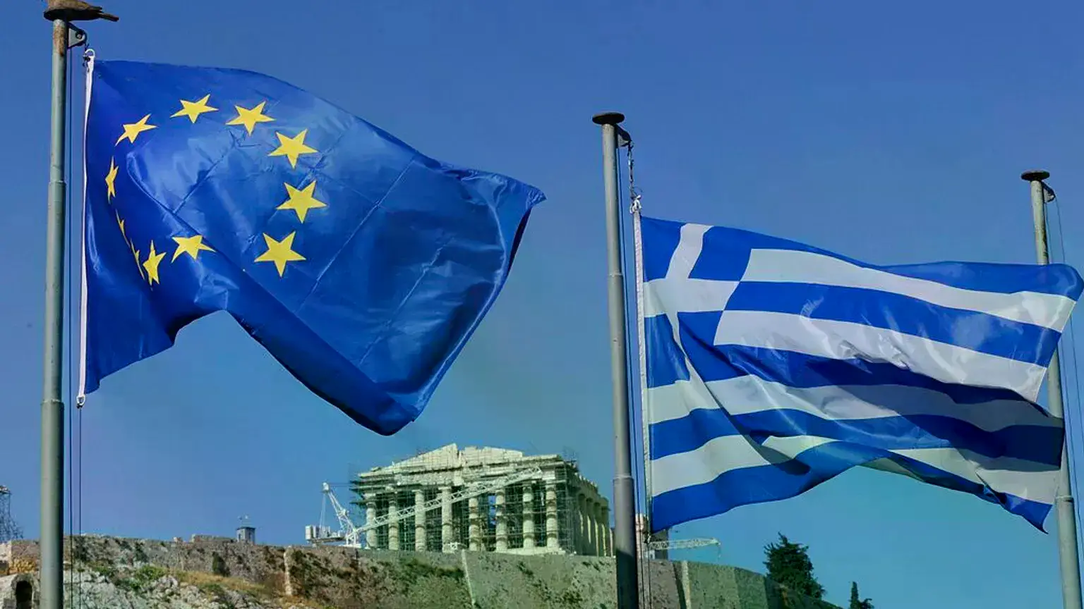 Las banderas griega y europea ondean bajo la Acrópolis en Atenas, en julio de 2015.
