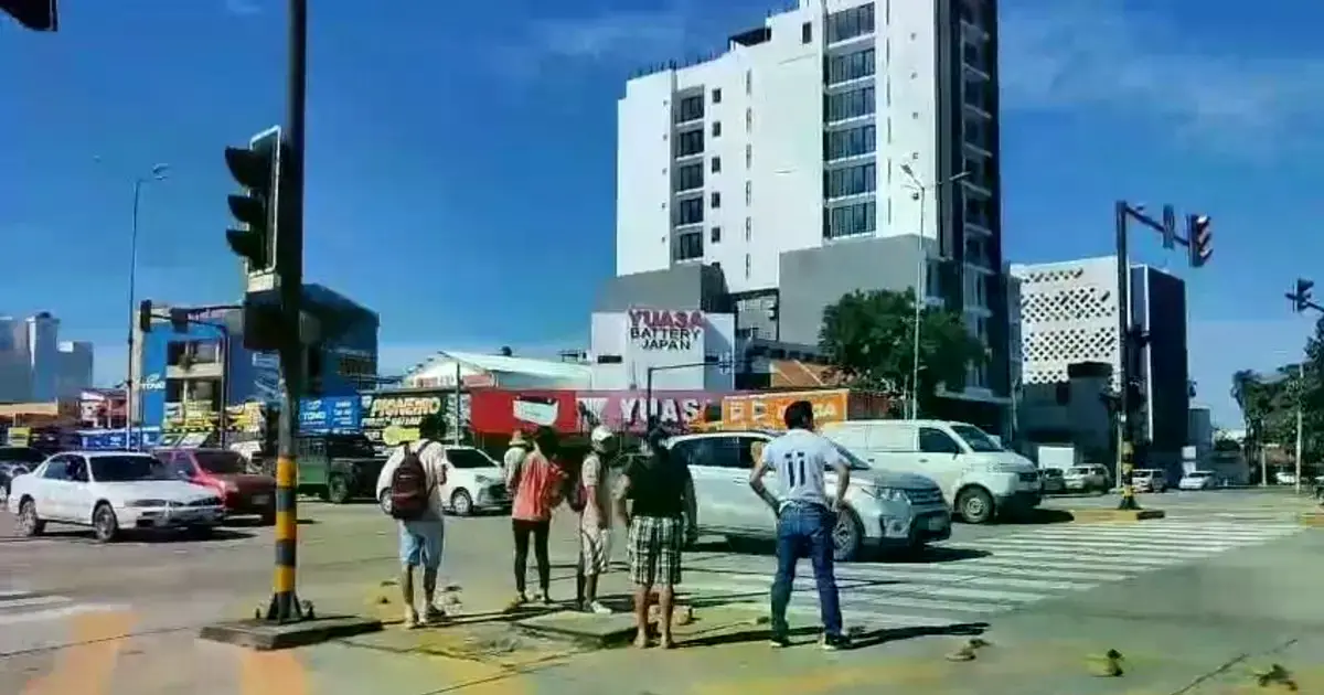 Personas aguardan en la calle la llegada de transporte público en Santa Cruz.