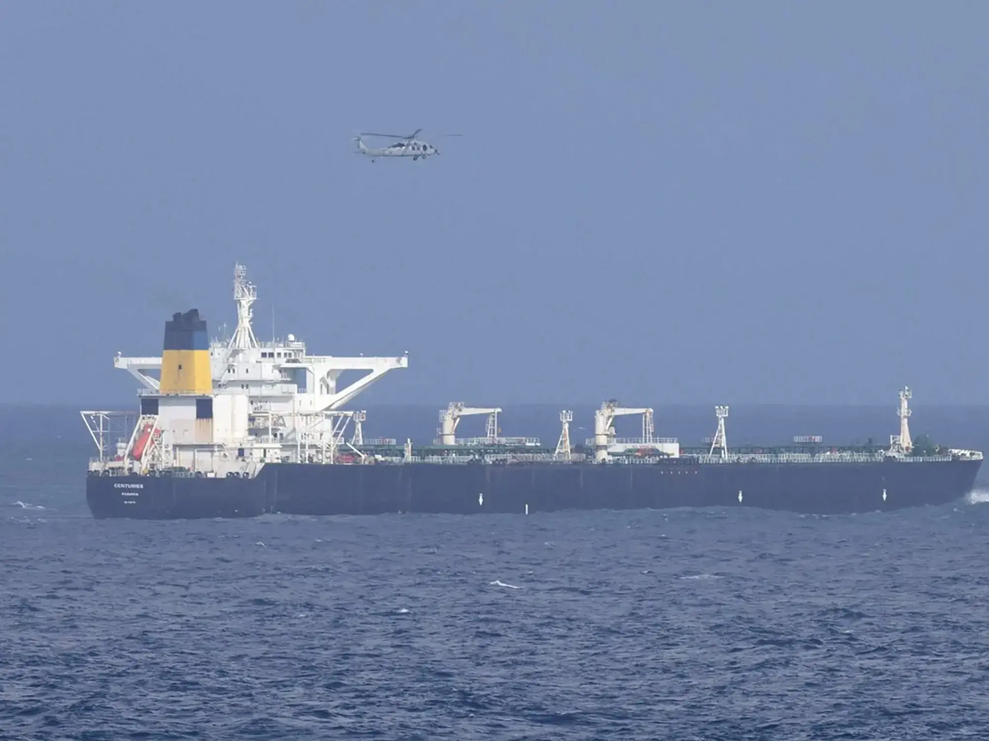 Un helicóptero militar estadounidense sobrevuela el buque cisterna Centuries, interceptado por la Guardia Costera.