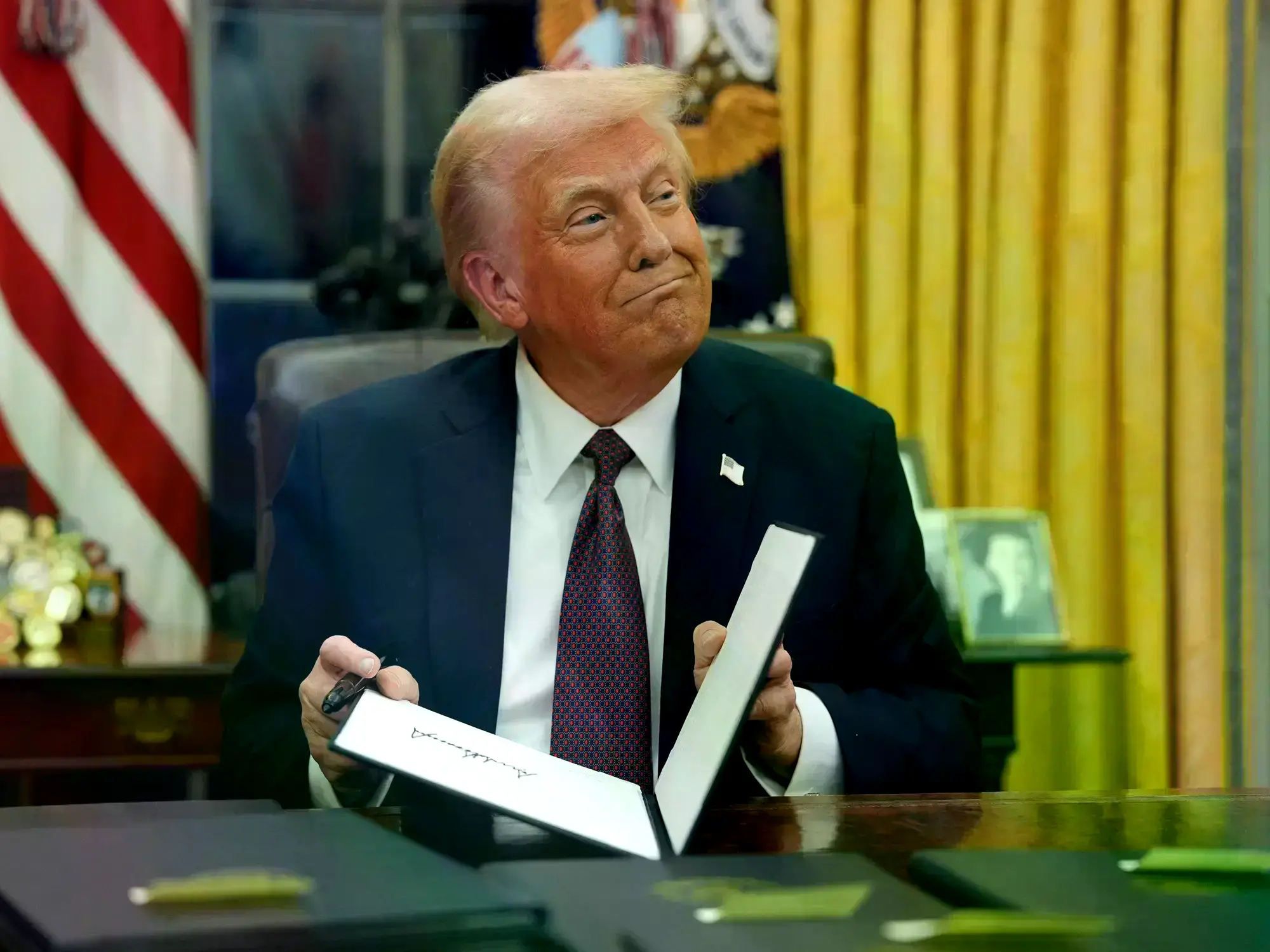 El presidente Donald Trump firma órdenes ejecutivas en la Oficina Oval de la Casa Blanca.