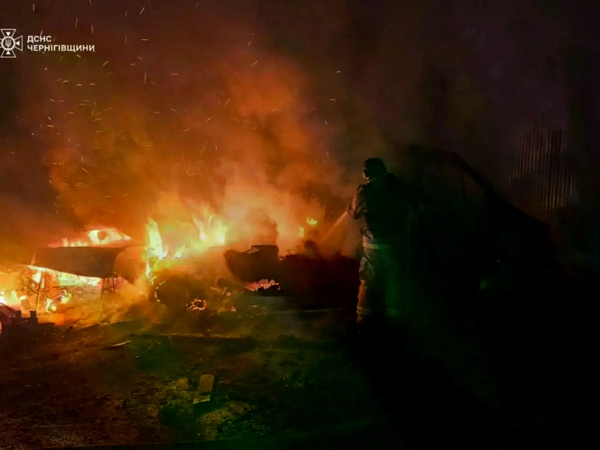 Bomberos tratan de apagar un auto en llamas tras un ataque aéreo de Rusia en la región de Chernihiv.