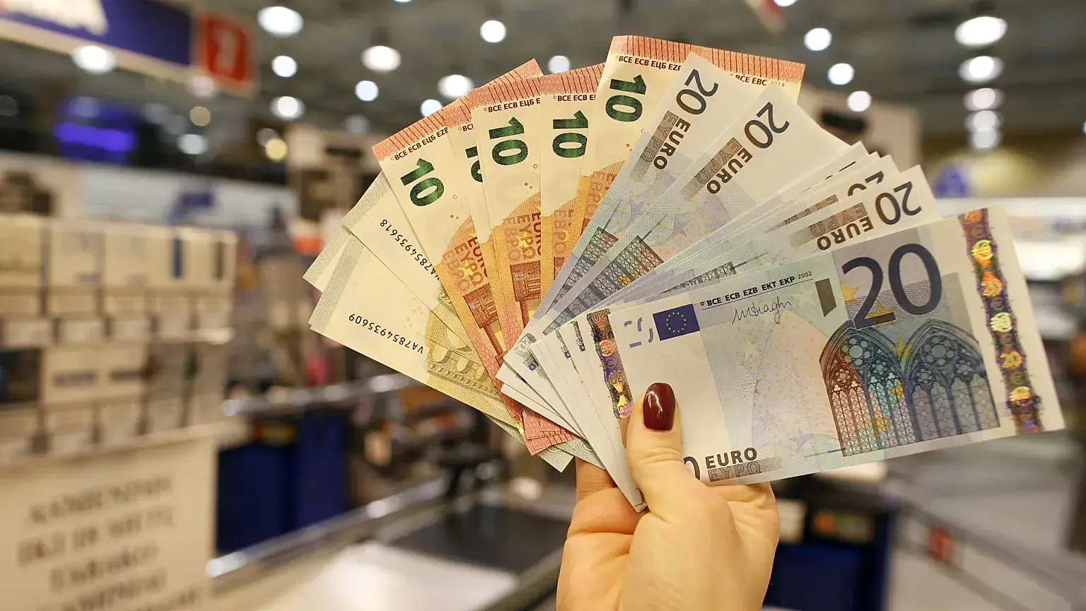 Un dependiente muestra billetes de euro en una tienda de Vilna, Lituania, en enero de 2015.