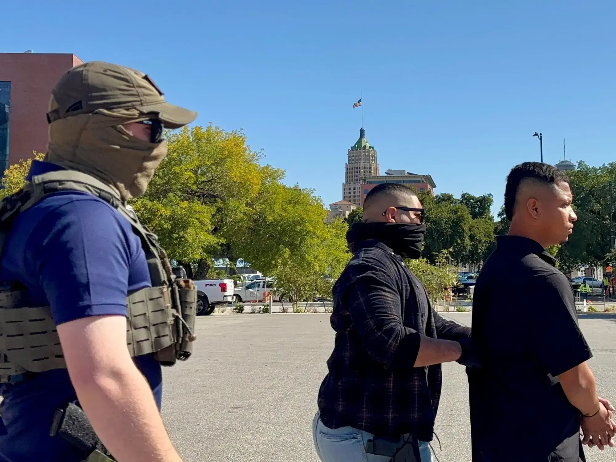 Agentes del ICE custodian a un migrante detenido en San Antonio, Texas.