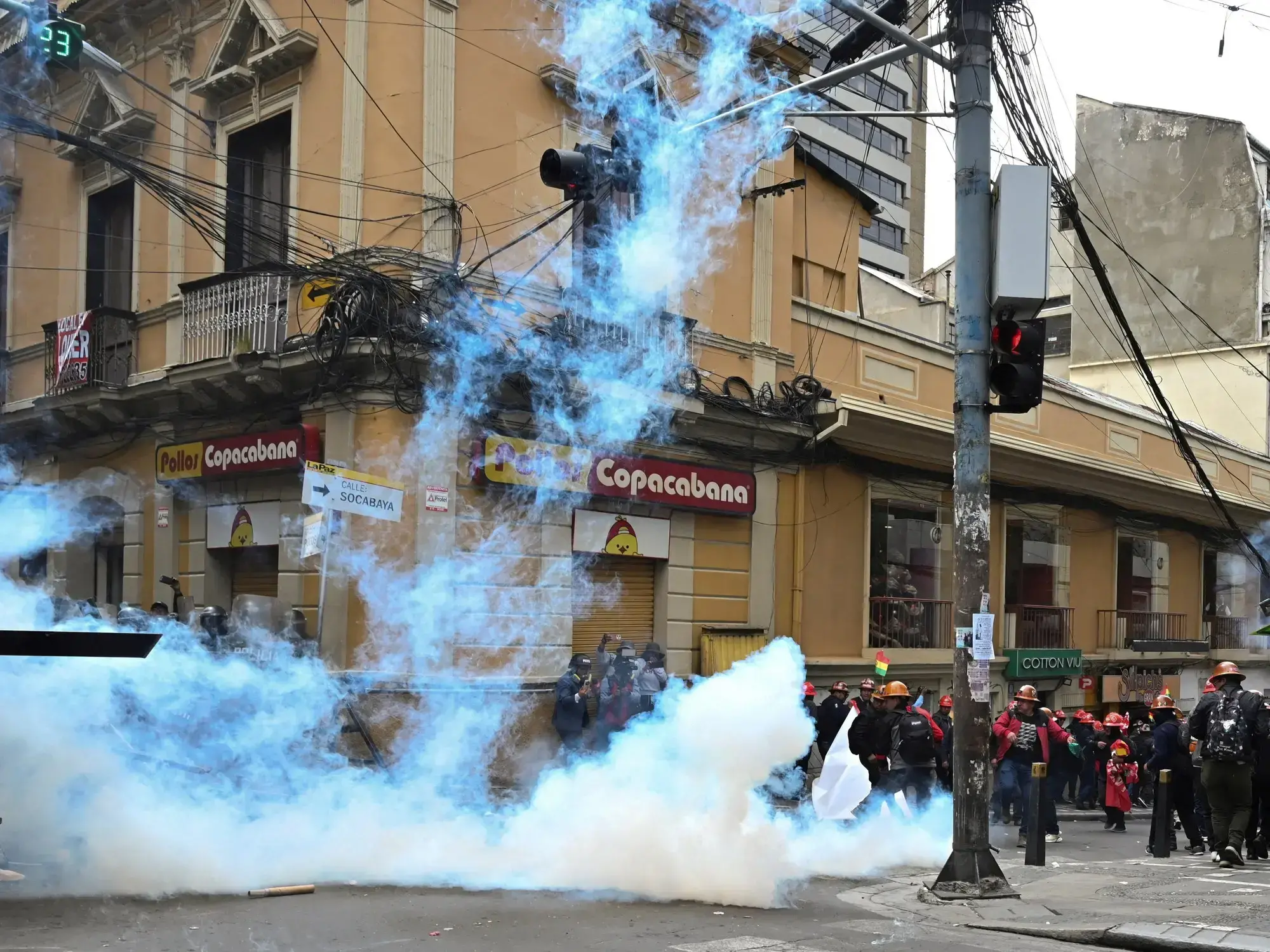 Manifestantes reaccionan a gases lacrimógenos durante enfrentamientos con la policía en una protesta en Bolivia.