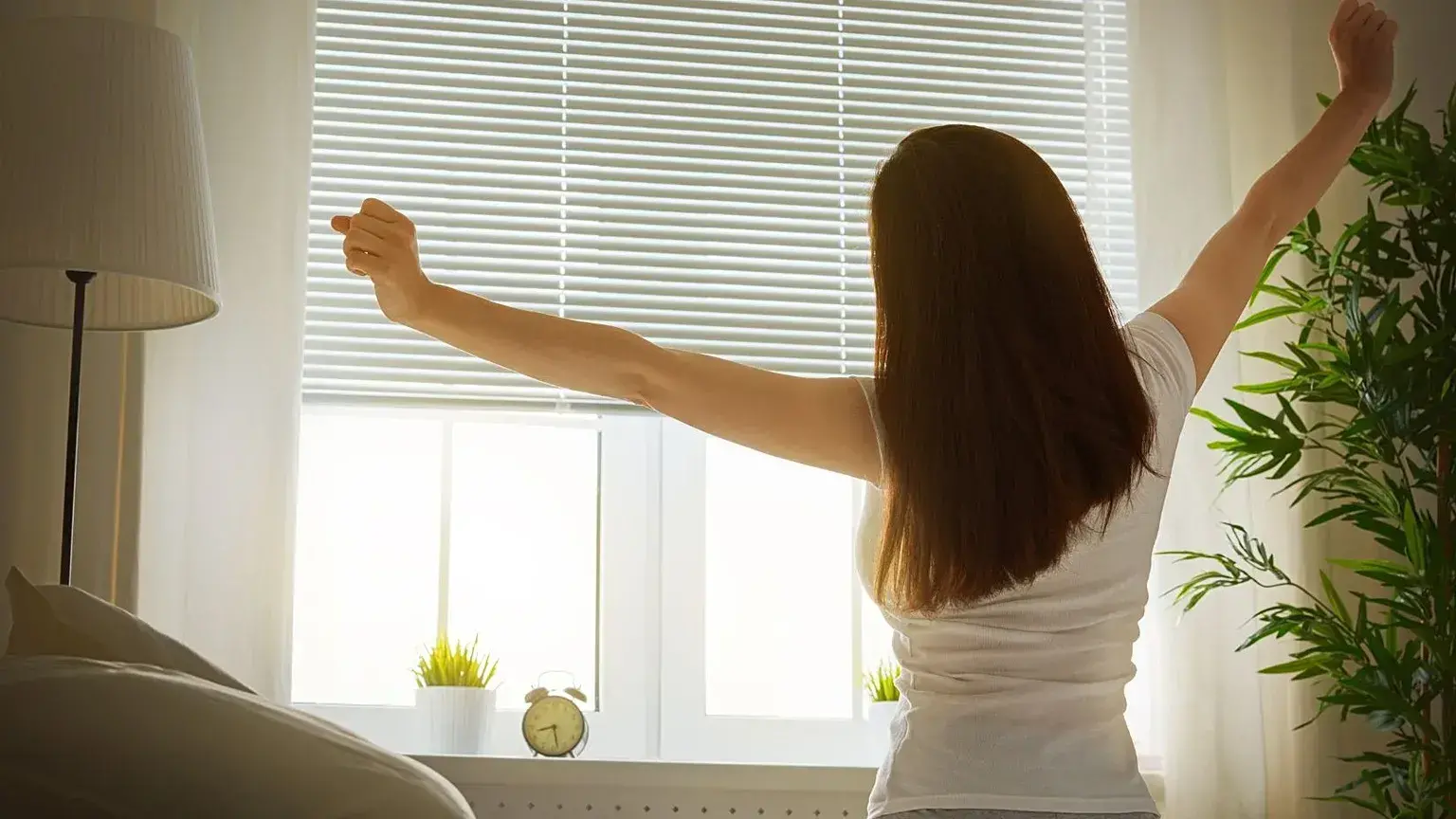 Una mujer realiza estiramientos por la mañana.