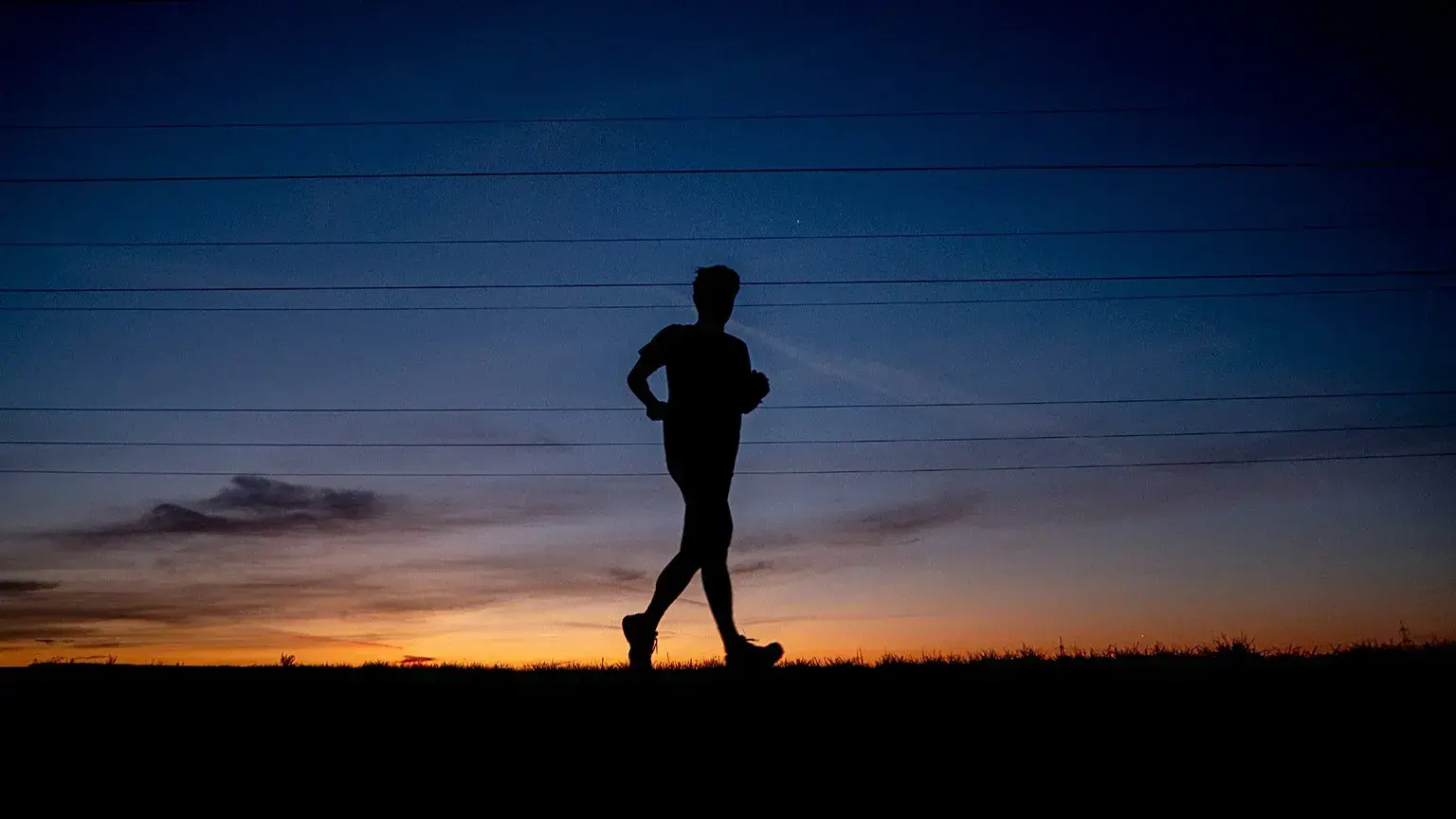 Un hombre corre por una carretera en las afueras de Fráncfort, Alemania, antes del amanecer.