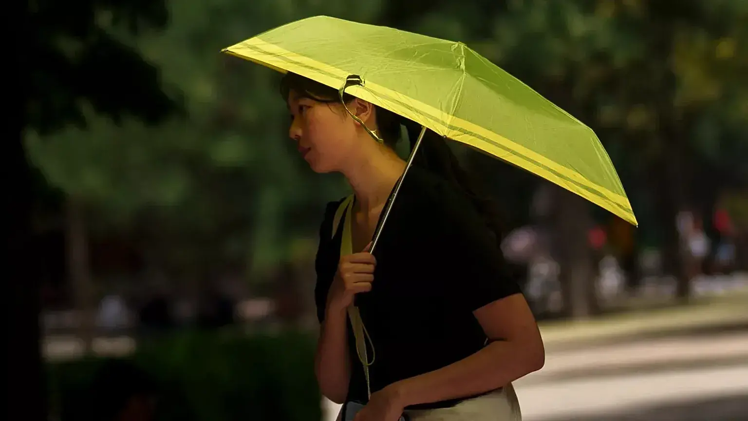 Una mujer se protege del sol en el parque del Retiro de Madrid, España, en julio de 2023.